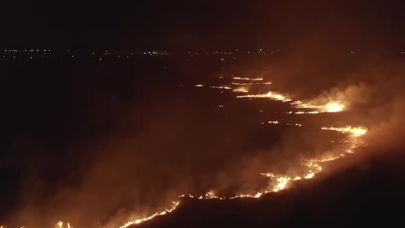 Forest Fire at Night Aerial Drone View Lights of City on Background
