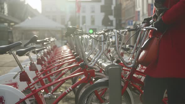Community bicycle rack with pedal assist bike share being mounted by pedestrian green energy low emi alt