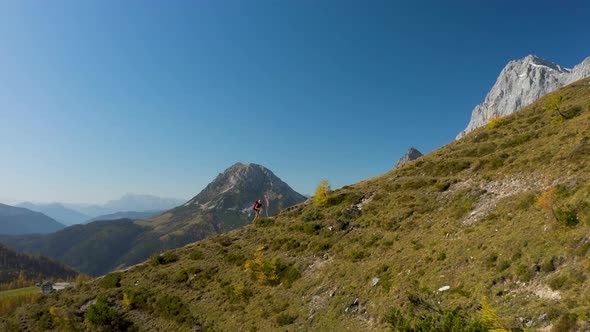 4K Aerial View Video Approaching Hiking Woman High up in Autumn Mountains