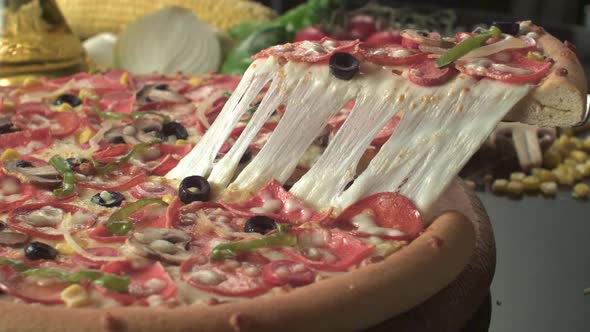 A pizza lifter takes out a slice from a pizza that has various of toppings