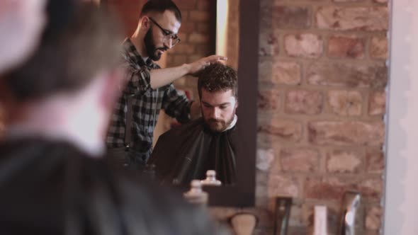 Young Adult Male having haircut in barbershop