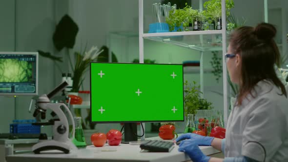 Pharmaceutical Researcher Looking at Computer with Mock Up Green Screen alt