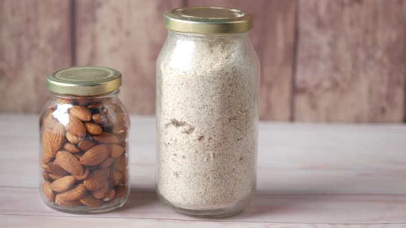 Almond Powder and Almond in a Jar on Table alt