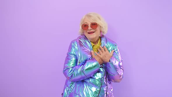 Modernly Dressed Woman of Retirement Age in Stylish Trendy Red Sunglasses Looks Flirty and Playful alt