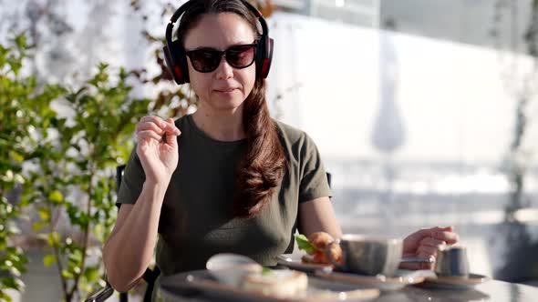 Attractive Adult Woman with Glasses Listening to Music with Headphones Use Smartphone During alt