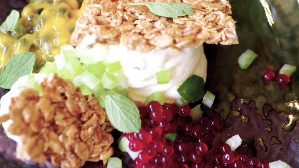 Fine dining starter of honey granola with passionfruit mousse, cherry pearls and origanum alt