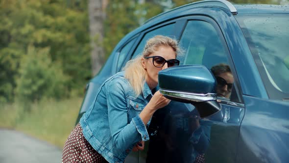 Lady Paints Her Lips With Lipstick. Outdoor Makeup Before Date With Boyfriend. Putting Lipstick. alt