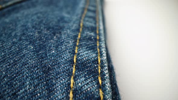 Extreme detailed of blue denim jeans texture in dolly shot over cloth surface. alt