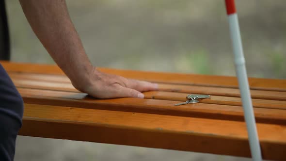 Blind Finding Lost Keys on Bench, Visual Challenges in Everyday Life of Impaired alt