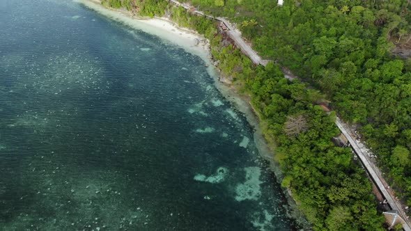 Aerial: Flying over tropical beach turquoise water coral reef , Indonesia alt