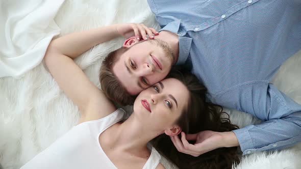 Young Loving Couple Lying on Bed at Home