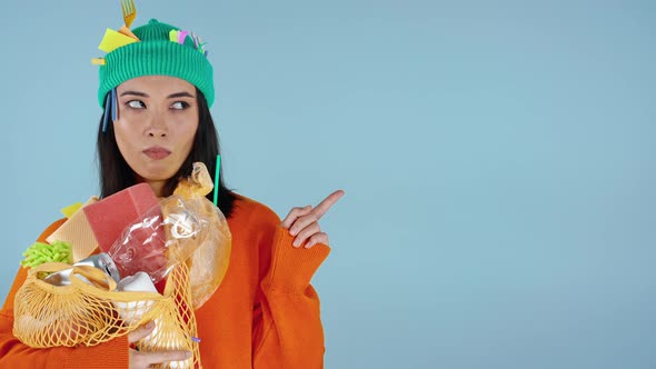 Woman with garbage on her clothes showing by finger on the background