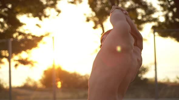 Metis Man with Blond Hair and Naked Torso Making Body Slopes Right and Left Training in Sunrise Time