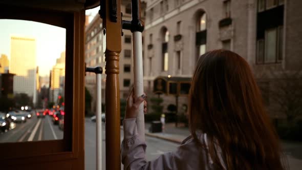 Woman using a tram on a city street alt