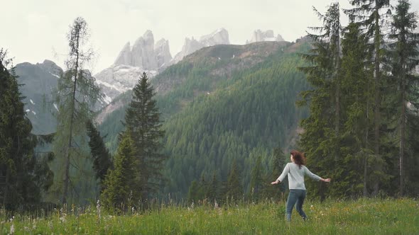 Slow Motion Shot of Happy Young Woman Spinning and Running in the Dolomites Northern Italy in the alt