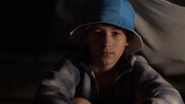 Portrait of a Sad Boy Hat Looking at the Camera in Dark Room Abandoned House