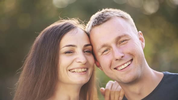 Portrait of Two Lovers Rejoices Together Isolated on Green Blur Background