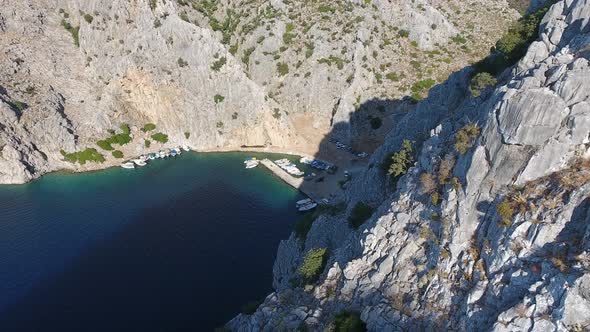 Small Fishing Harbor in a Narrow Valley Between Steep Walled Rocky Mountains