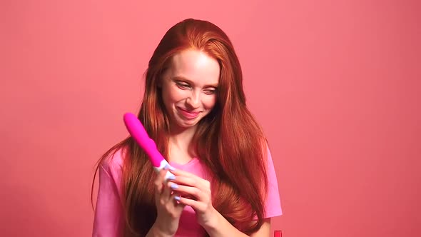 Redhaired Ginger Woman in Pink Studio Background Useing Vibrator and Feeling Embarrassment alt