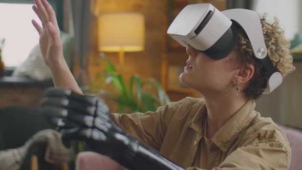 Girl with Prosthetic Arm Playing Game with VR Headset alt