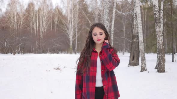 Charming Female with Long Hair Walking in Snowy Forest