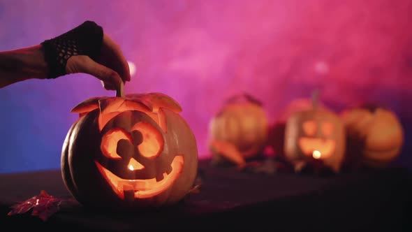 Witch lights pumpkin for halloween.  Set fire to pumpkin. Halloween!  4K.  Stock video.