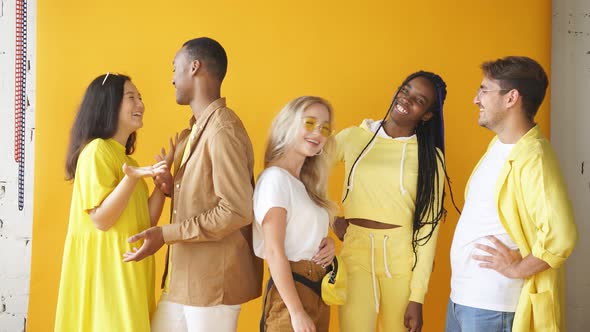 Friendly Multiethnic Group of Youth Have Conversation Isolated on Yellow Background alt
