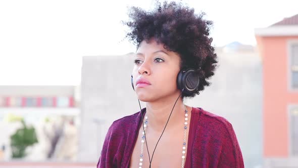 Young black woman listening music headphones serene alt