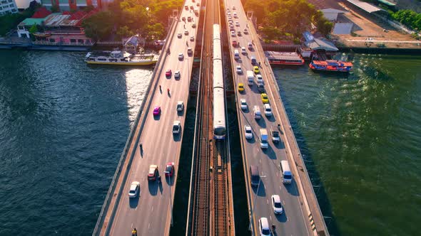 Aerial view flight over moving sky train on a bridge over the Chao Phraya River alt