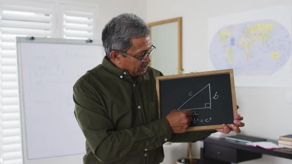 Mixed race male teacher standing at a whiteboard giving an online lesson to camera alt