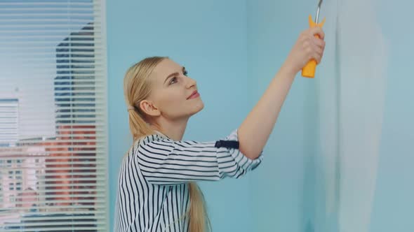 Woman Painting a Wall at Office alt