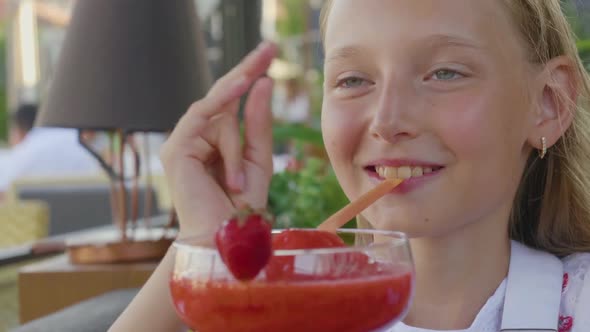 Happy Girl Teenager Drinking Strawberry Cocktail By Straw in Summer Cafe alt