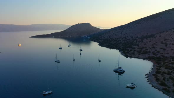 Catamaran and Sail Yachts Anchored at Bay on Deep Blue Sea Water on Sunrise alt