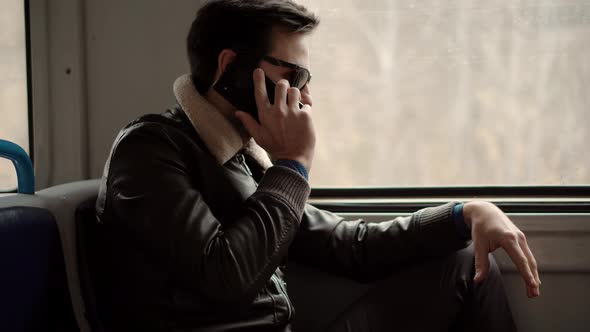 Man In Sunglasses Using Mobile Phone And Call To Friends. Man Talking On Smartphone In Train. alt