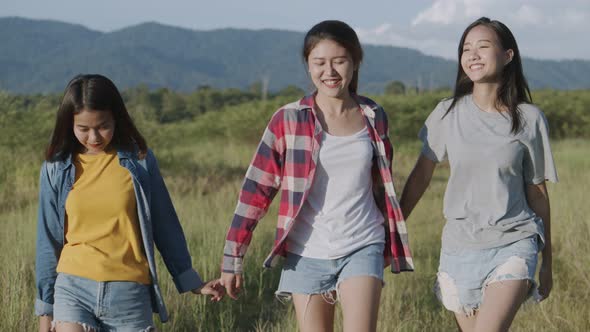 Group of a young Asian woman holding hands walking having fun together a summer traveling.