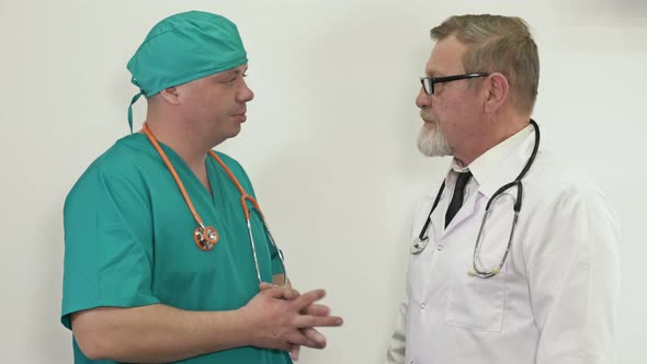 Two Doctors an Elderly and a Young One Have Met in the Hospital Corridor and are Talking About alt