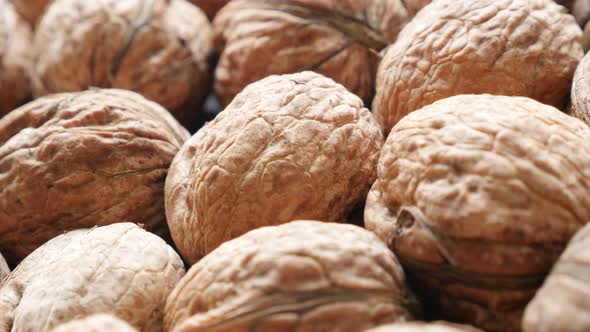 Walnut fruit pieces background  arranged on the table slow pan 4K 2160p 30fps UltraHD video - Food b alt
