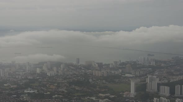 Aerial view Penang Bridge and Georgetown city in misty morning from Penang Hill. alt