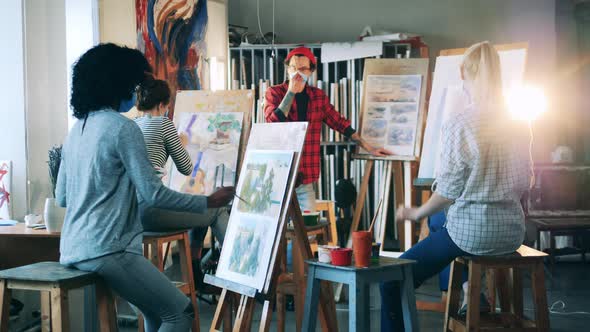 Art Teacher in a Face Mask Is Holding a Class To a Group of Students alt