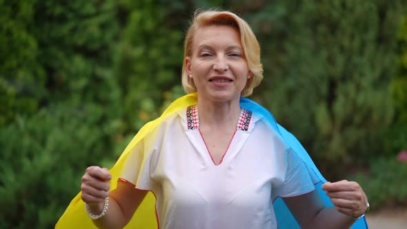 Front View Portrait of Confident Brave Woman Posing with Ukrainian Flag in Slow Motion alt