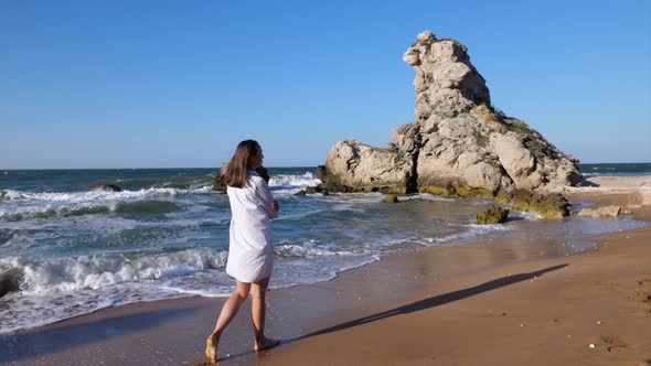 Young Attractive Woman Is Walking on the Beach Alone.