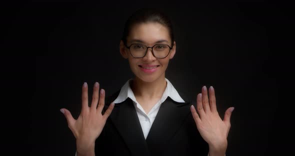 Asian Woman in Glasses Smiling and Shows Ten Fingers with Her Right Hand