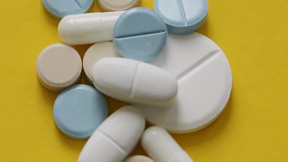 Top View Rotation  Pills and Capsules on a Yellow Background Closeup alt