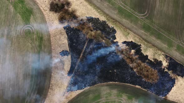 Top Aerial view of Smoking wild fire in Africa. Flying above  Wildfires. Dry Grass burning alt