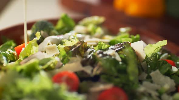 Camera follows dressingbeing pouring over salad. 4K 30fps. Slow Motion. alt