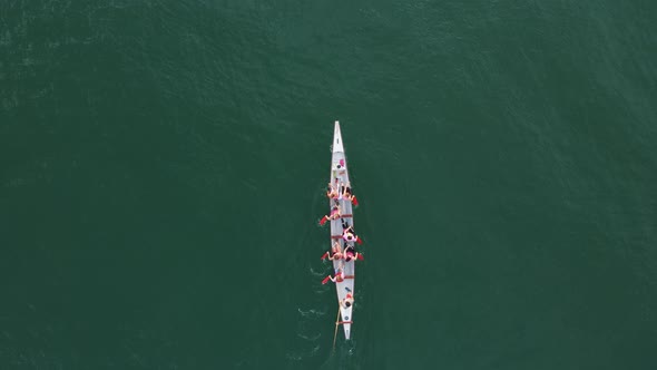 Sport Canoe with a team rowing on tranquil water, Aerial view.
