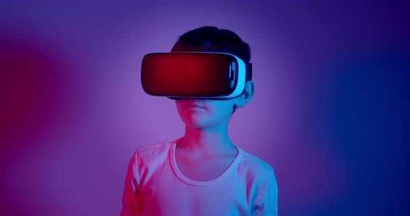 Boy Wearing VR Glasses Against Blue and Purple Background