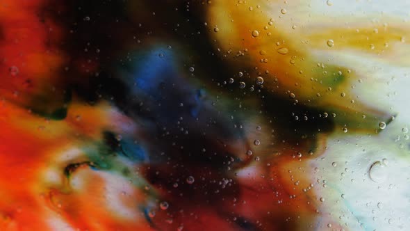 Transparent Space Liquid is Filled with Drops of Red Blue Yellow and Green Paint alt