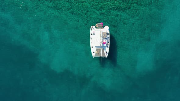 Woman in Bikini Tanning and Relaxing on a Summer Catamaran Sailing Cruise alt