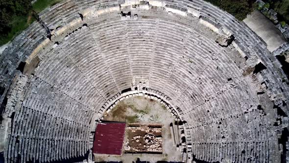High angle drone aerial view of ancient greek rock cut lykian empire amphitheatre and tombs in Myra alt
